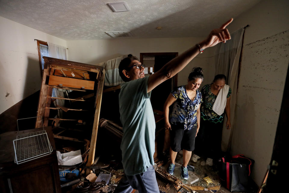 Smita Depani, center, stands in the apartment she lived in while surveying the damage with her brother-in-law Jayanti Depani, left, and sister-in-law Puspa Manvar in the motel they own which was destroyed in the flooding from Hurricane Florence in Spring Lake, N.C., Wednesday, Sept. 19, 2018. (AP Photo/David Goldman)