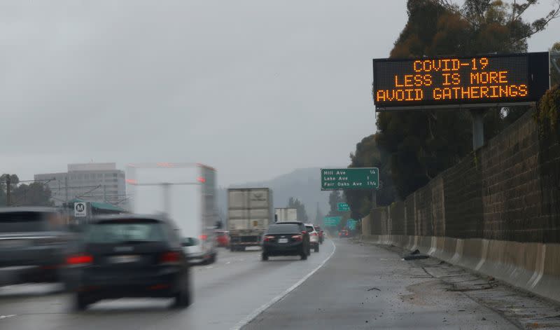FILE PHOTO: A highway sign usually used for traffic reports advises drivers to practice social distancing due to the global outbreak of coronavirus (COVID-19) in Pasadena