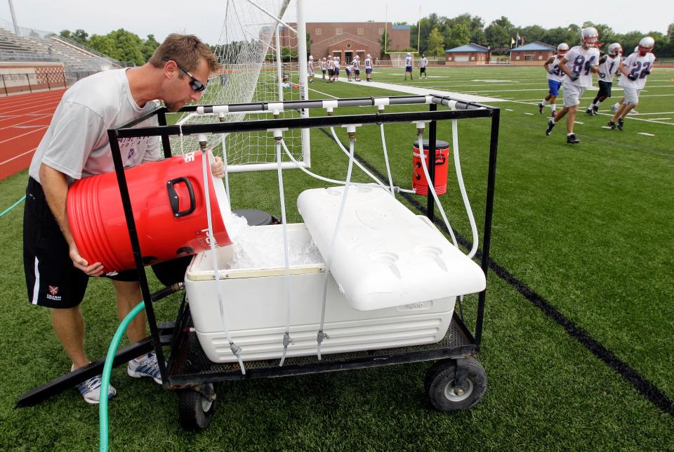 Football teams at all levels should have plenty of water available for players at practice and at games. Here, an athletic trainer prepares a water station at Father Ryan High School in Nashville.