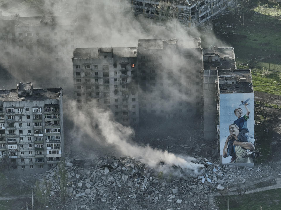 FILE - Smoke rises from a building in Bakhmut, the site of the heaviest battles with the Russian troops in the Donetsk region, Ukraine, Wednesday, April 26, 2023. Ukrainian President Volodymyr Zelenskyy said Sunday, May 21, 2023 that Russian forces weren't occupying Bakhmut, casting doubt on Moscow's insistence that the eastern Ukrainian city had fallen. The fog of war made it impossible to confirm the situation on the ground in the invasion’s longest battle, and the comments from Ukrainian and Russian officials added confusion to the matter. (AP Photo/Libkos, File)