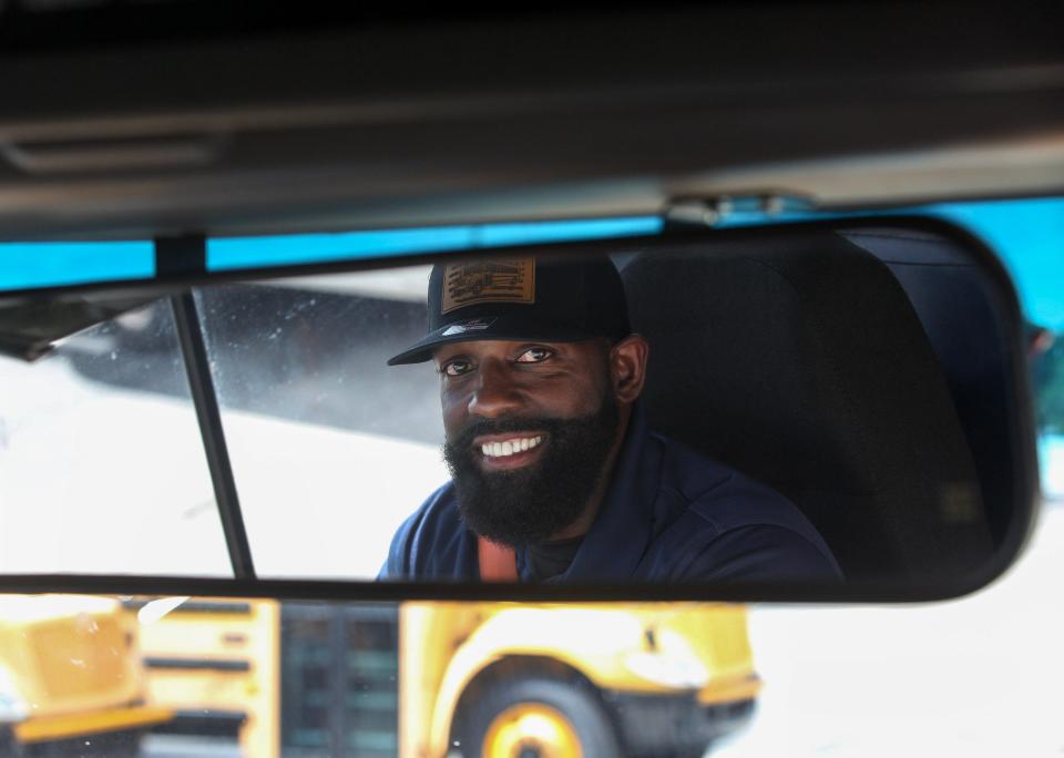 St. Lucie County bus driver, Michael Brown, demonstrates his role on his school bus, Wednesday, Oct. 18, 2023, at the St. Lucie County school board bus compound. "Attitude is everything," Brown said. "I'm the first person that they see, so I want that to be a moment to see that smiling face. I think that helps them go through their day. We don't know what they go through when they're not with us, so it's important."