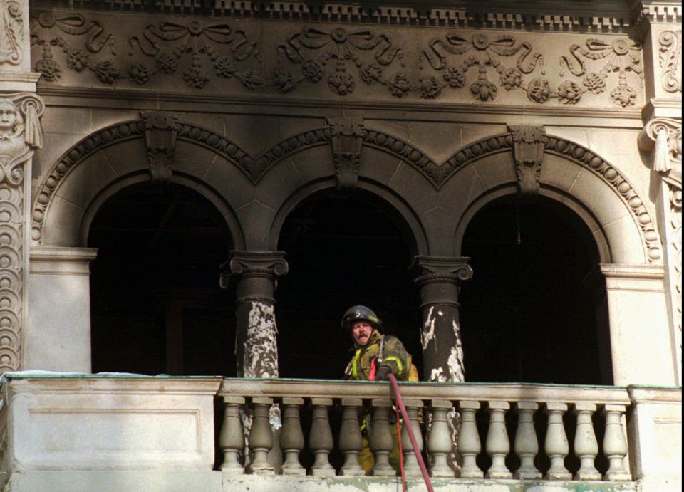 A fireman pulls up a hose onto the second floor of the Governor’s Mansion where a fire destroyed much of the interior inside the building after a Christmas tree fire on Dec. 15, 1993, in Salt Lake City, Utah. | Jeffrey D. Allred, Deseret News