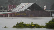 Flood waters surround an industrial property in Londonderry on the outskirts of Sydney, Australia, Monday, July 4, 2022. More than 30,000 residents of Sydney and its surrounds have been told to evacuate or prepare to abandon their homes on Monday as Australia's largest city braces for what could be its worst flooding in 18 months. (AP Photo/Mark Baker)