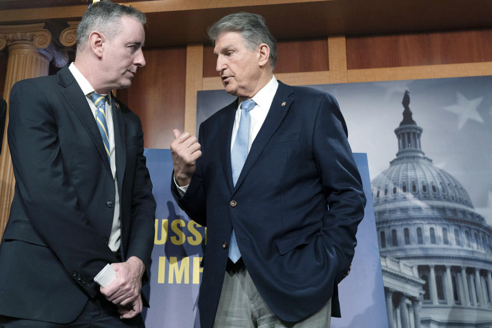 Rep. Brian Fitzpatrick, R-Pa., left, listens to Sen. Joe Manchin, D-W.Va., as they attend a news conference about a bill to ban Russian energy imports, Thursday, March 3, 2022, on Capitol Hill in Washington. (AP Photo/Jacquelyn Martin)