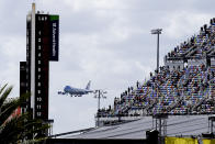 Fans watch from the grandstands as Air Force One circles the Daytona International Speedway as President Donald Trump makes his arrival to attend the NASCAR Daytona 500 auto race at Daytona International Speedway, Sunday, Feb. 16, 2020, in Daytona Beach, Fla. (AP Photo/Terry Renna)