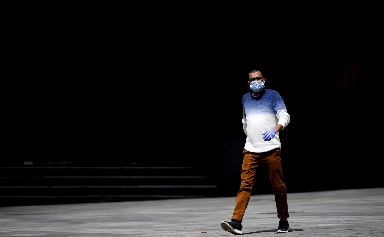 MADRID, SPAIN - APRIL 24:  A pedestrian wears a face mask as a precaution against transmission of the Covid-19 on April 24, 2020 in Madrid, Spain. Starting last week, some businesses deemed non-essential have been allowed to resume operations, and it is expected that from April 27 children under 12 will be allowed to come and go from their homes more freely. Spain has had more than 200,000 confirmed cases of COVID-19 and over 20,000 reported deaths, although the rate has declined after weeks of lockdown measures. (Photo by Samuel de Roman/Getty Images)