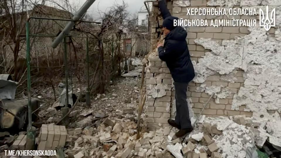 This still from a video shows a person standing among rubble of a building hit and damaged by shelling in Kherson (via REUTERS)