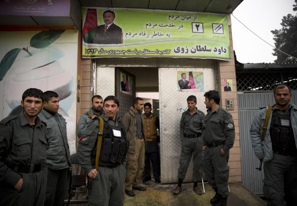 In this Sunday, March 16, 2014 photo, Afghan policemen secure the headquarters of Daoud Sultanzoi, a presidential candidate and former Parliamentarian from Afghanistan’s central Ghazni province, in Kabul, Afghanistan. Sultanzoi said he’s infuriated by arguments he hears from some Afghans that the presence of warlords and ethnic strongmen is the best that can be expected in Afghanistan and that the county is not ready for Western-style democracy. (AP Photo/Anja Niedringhaus)