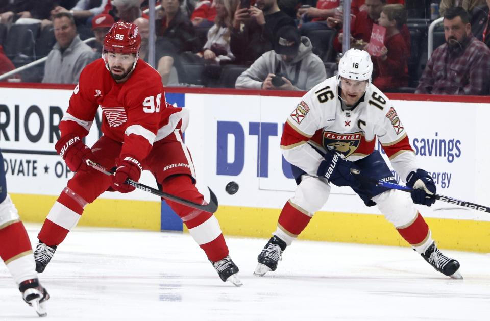 Detroit Red Wings defenseman Jake Walman (96) passes the puck against Florida Panthers center Aleksander Barkov (16) during the first period of an NHL hockey game Saturday, March 2, 2024, in Detroit. (AP Photo/Duane Burleson)