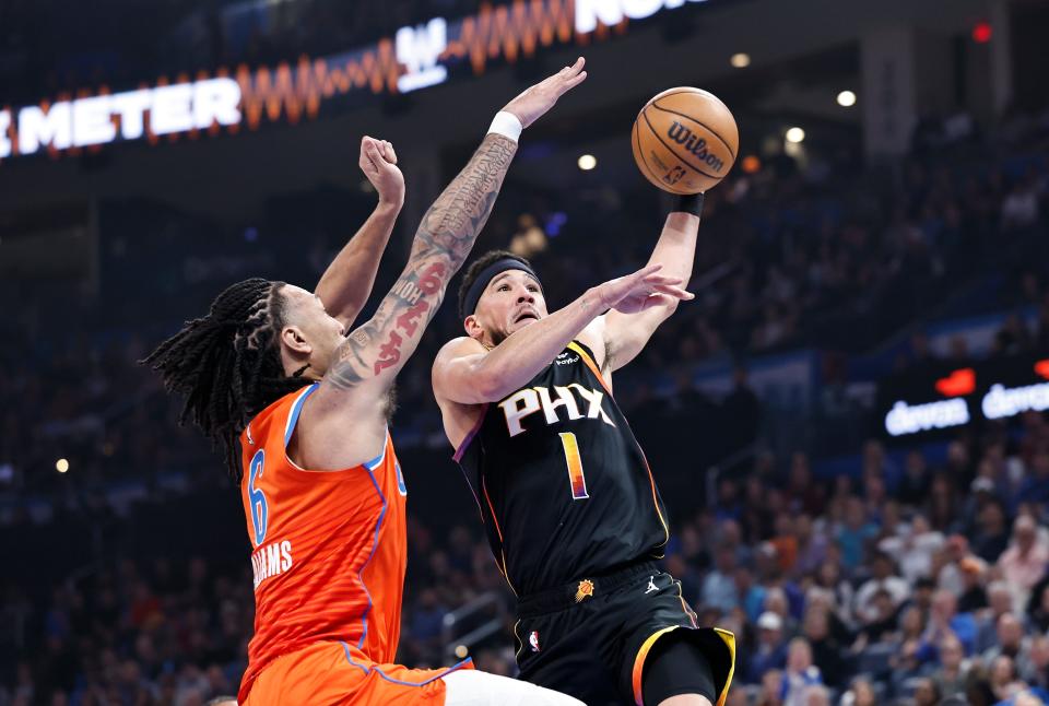 Phoenix Suns guard Devin Booker (1) goes up for a basket as Oklahoma City Thunder forward Jaylin Williams (6) defends during the first half at Paycom Center.