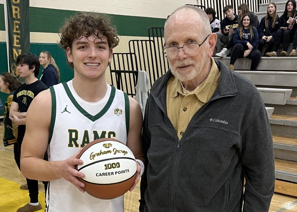 Graham Junge (left) celebrated reaching 1,000 career points Tuesday night with Ron Schroeder, the first player to reach that milestone for Flat Rock. Junge scored 29 points to lead the Rams past Grosse Ile 73-40.