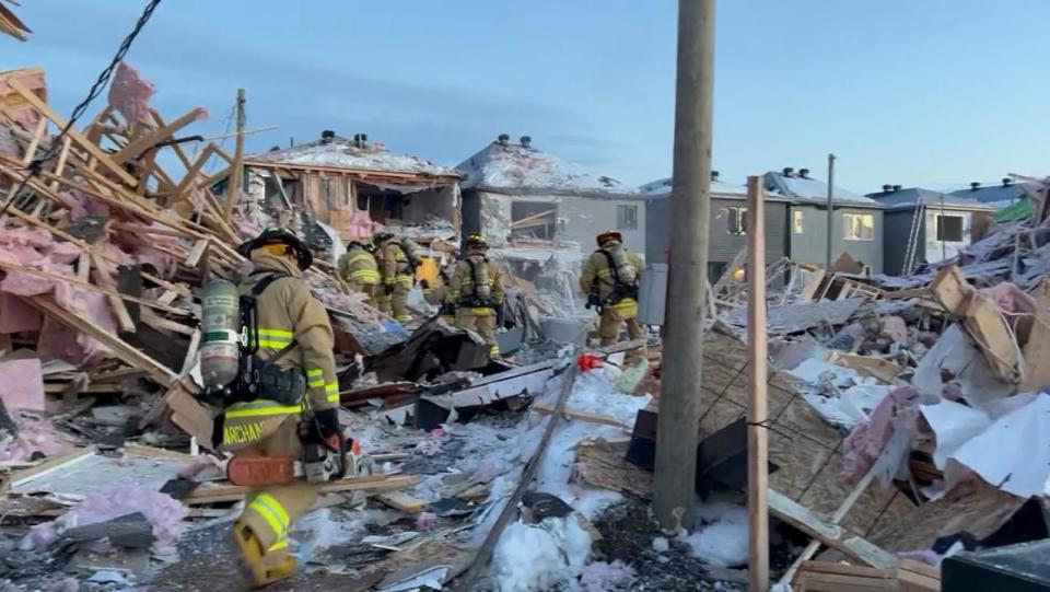 Firefighters comb though the wreckage of an explosion in east Ottawa the morning of Feb. 13, 2023.