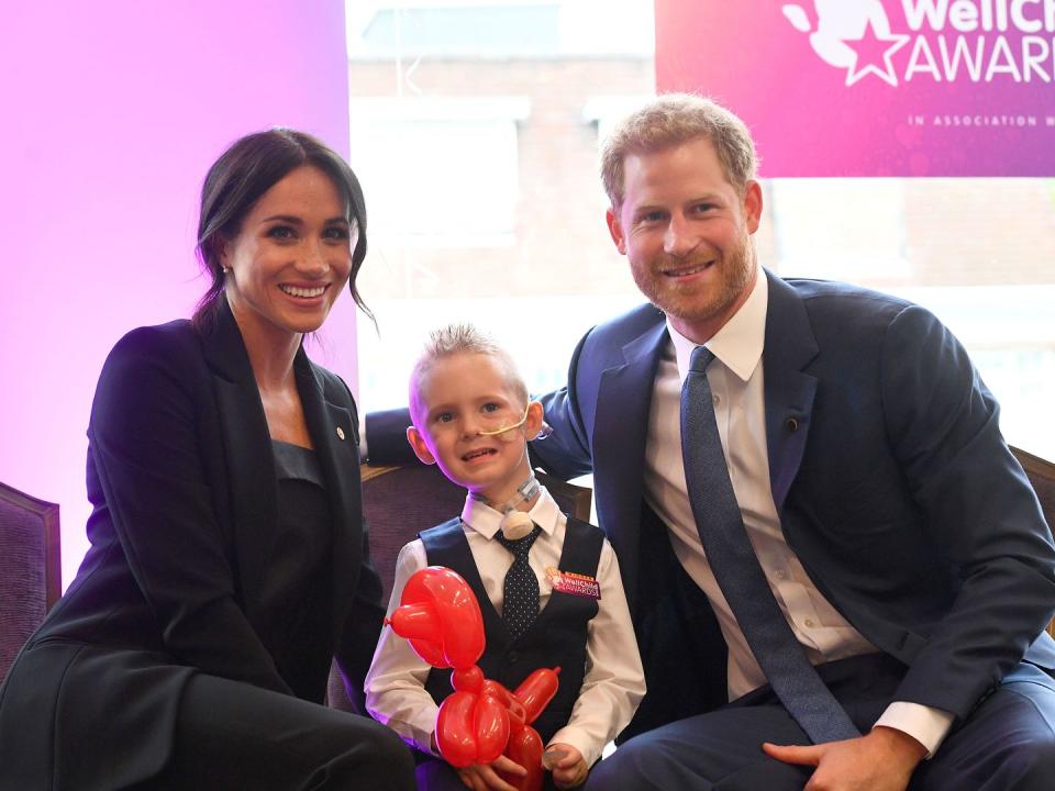 <p>Meghan and Harry pose with four-year-old Mckenzie Brackley during the annual WellChild awards.</p>