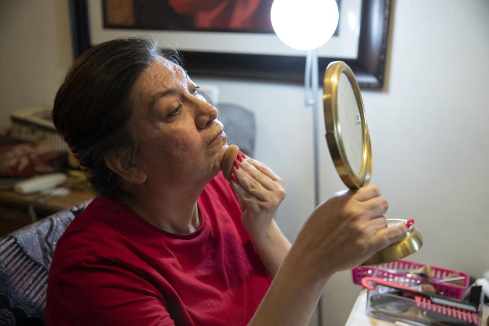 Christina Wood applies makeup and gets ready before going to work in her home in Salem, Ore., Friday, April 21, 2023. Six years ago, Wood moved to Oregon, where she could access the gender-affirming health care she needed to live as her authentic self. Once there, Wood was able to receive certain surgeries that helped her transition, but electrolysis, or permanent hair removal, wasn’t fully covered under the state’s Medicaid plan for low-income residents. Democratic lawmakers in Oregon are advancing a bill that would expand insurance coverage for gender-affirming care to include things like facial hair removal and Adam’s apple reduction surgery. (AP Photo/Amanda Loman)