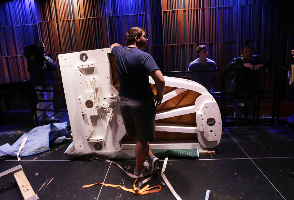 Workers set up a white Steinway grand piano, salvaged from the flooded Lower 9th Ward home of legendary musician Fats Domino after Hurricane Katrina, after being restored in New Orleans, Thursday, May 2, 2013. Its restoration came through $30,000 donated to the Louisiana Museum Foundation, and will be the centerpiece of an exhibit in the French Quarter. (AP Photo/Gerald Herbert)