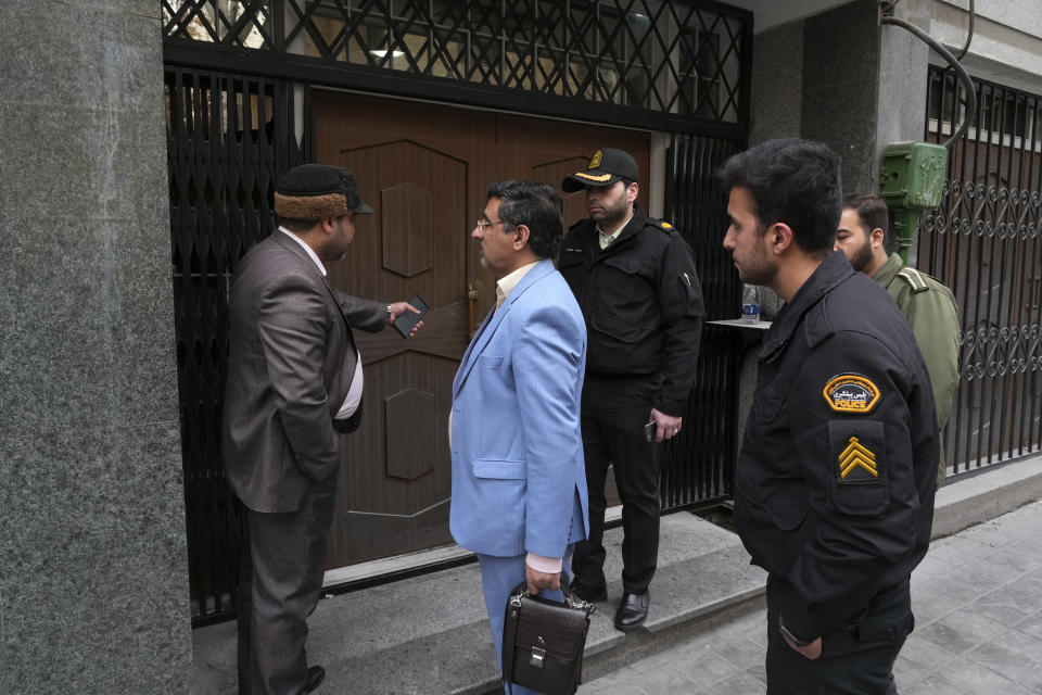 Police and judiciary officials talk in front of the door of the building of the Azerbaijan Embassy in Tehran, Iran, Friday, Jan. 27, 2023. A man armed with a Kalashnikov-style rifle stormed the Azerbaijan Embassy in Iran's capital Friday, killing the head of security at the diplomatic post and wounding two guards, authorities said. (AP Photo/Vahid Salemi)