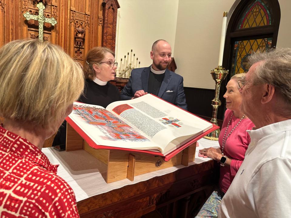 St. John’s Episcopal Church clergy, the Rev. Leslie Roraback, Associate Rector, and the Rev. Lonnie Lacy, Rector, share The Saint John’s Bible with a group of parishioners ahead of St. John's 72-hour marathon Bible reading on Aug. 24, 2023.