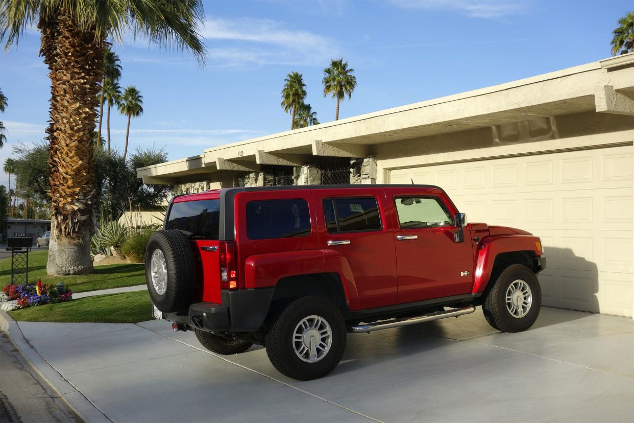 Red Hummer H3 SUV parked on residential diveway