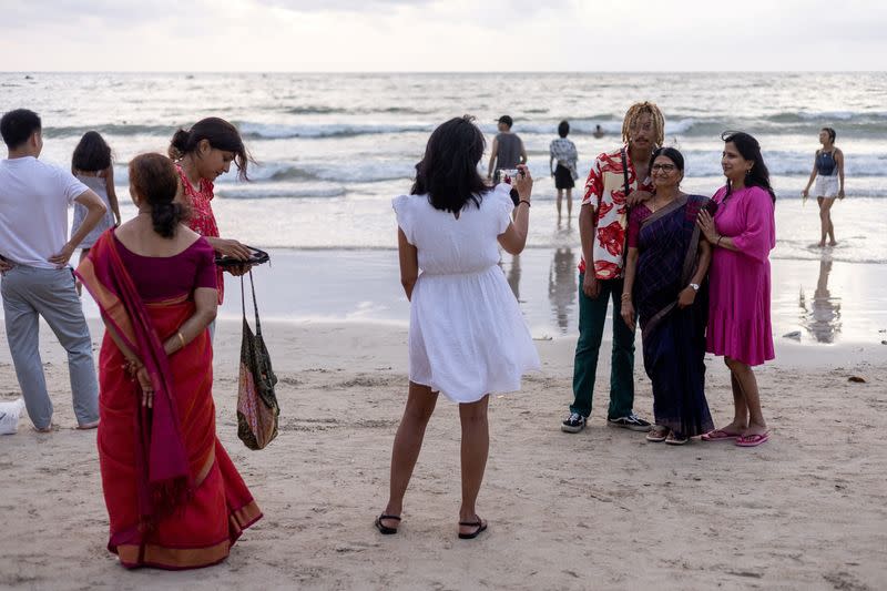 Members of the Shivkumar-Manjunatha family from India walk and take pictures during their first time familiy holiday trip to Thailand at Patong beach in the island of Phuket