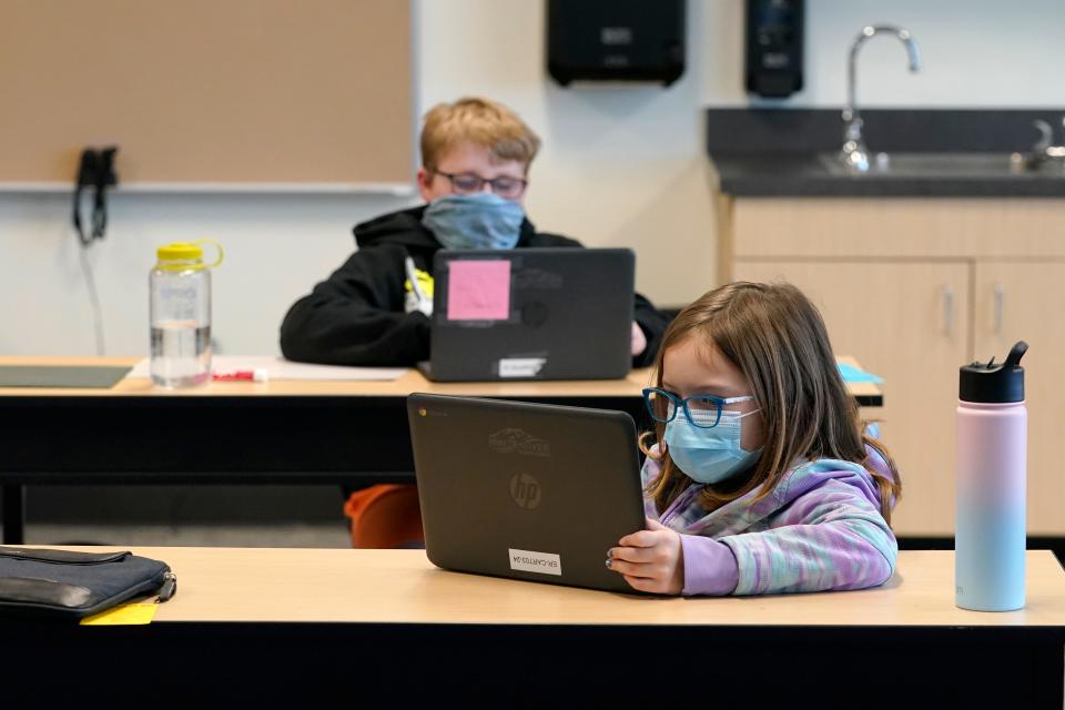 Students wear masks as they work in a fourth-grade classroom, Feb. 2, 2021, at Elk Ridge Elementary School in Buckley, Wash. The school has had some students in classrooms for in-person learning since September of 2020, but other students who attend the school are still learning remotely. 