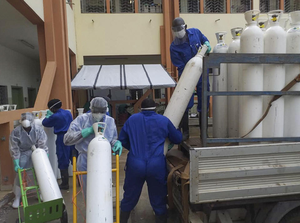 Medical workers offload cylinders of oxygen at the Donka public hospital where coronavirus patients are treated in Conakry, Guinea, on Wednesday, May 20, 2020. Before the coronavirus crisis, the hospital in the capital was going through 20 oxygen cylinders a day. By May, the hospital was at 40 a day and rising, according to Dr. Billy Sivahera of the aid group Alliance for International Medical Action. Oxygen is the the facility's fastest-growing expense, and the daily deliveries of cylinders are taking their toll on budgets. (AP Photo/Youssouf Bah)