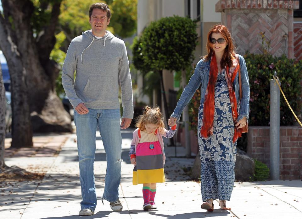 Alexis Denisof and a pregnant Alyson Hannigan step out for a walk with their daughter, Satyana.