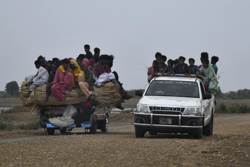 Local residents travel on a vehicle as they flee from a coastal village due to Cyclone Biparjoy approaching, in Golarchi near Badin, Pakistan's southern district in the Sindh province, Wednesday, June 14, 2023. The coastal regions of India and Pakistan were on high alert Wednesday with tens of thousands being evacuated a day before Cyclone Biparjoy was expected to make landfall. (AP Photo/Umair Rajput)