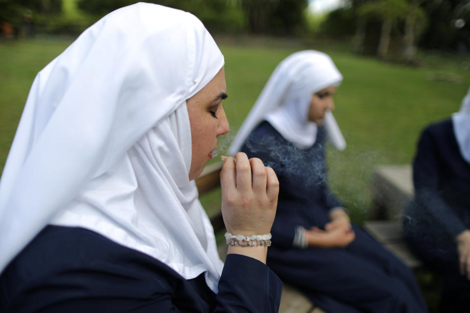 California "weed nun" Desiree Calderon, who goes by the name Sister Freya (L), and India Delgado, who goes by the name Sister Eevee, smoke a joint at Sisters of the Valley near Merced, California, U.S., April 18, 2017. Picture taken April 18, 2017. REUTERS/Lucy Nicholson