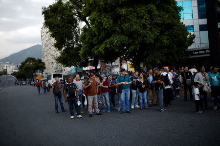 People wait for transportation in front of a closed metro station during a blackout in Caracas, Venezuela February 6, 2018. REUTERS/Carlos Garcia Rawlins