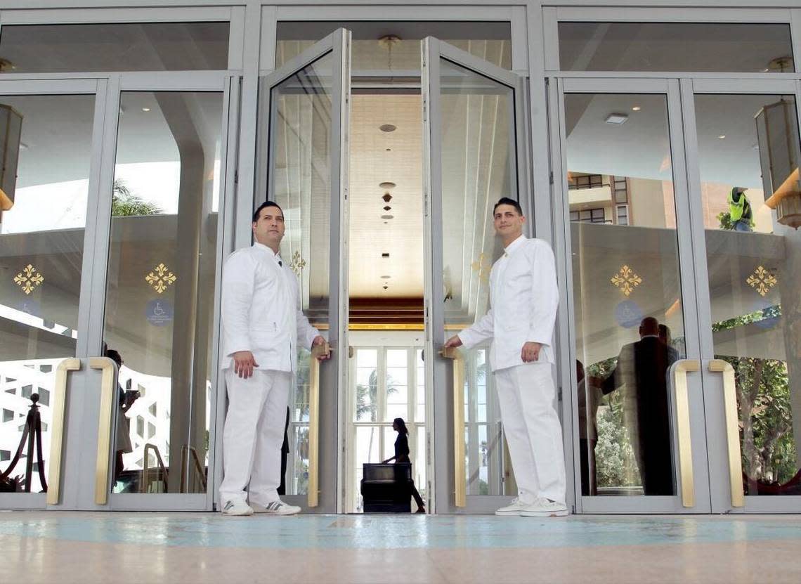 Porters Yandy Lopez, left, 41, and Felix Alpizar, 38, hold the door for guests as they enter the signature lobby space of the Faena Hotel which opened in 2015