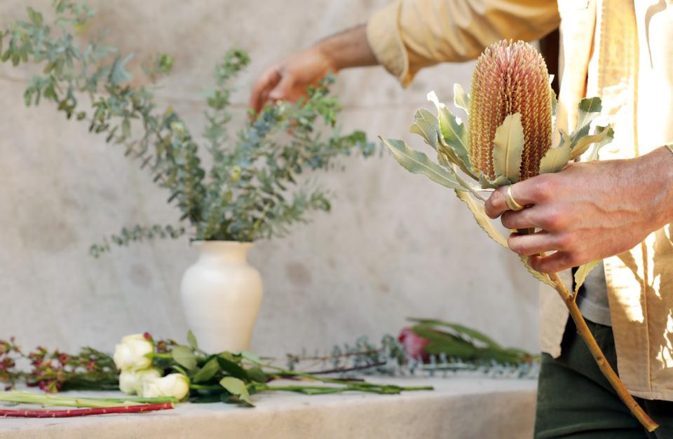 Spencer Falls prepares a backdrop of eucalyptus greens before adding his first showstopper bloom of banksia.