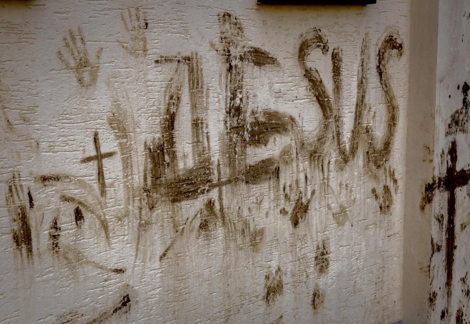 The letters "Jesus" are written with mud at a damaged house in the village of Ahrweiler in the Ahrtal valley, Germany, Tuesday, July 5, 2022. Flooding caused by heavy rain hit the region on July 14, 2021, causing the death of about 130 people. (AP Photo/Michael Probst)