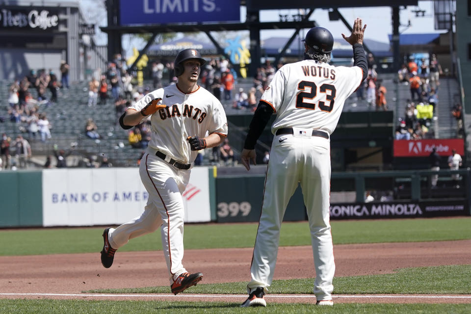 San Francisco Giants' Alex Dickerson, left, is congratulated by third base coach Ron Wotus, right, after hitting a solo home run against the Colorado Rockies during the first inning of a baseball game in San Francisco, Sunday, April 11, 2021. (AP Photo/Jeff Chiu)