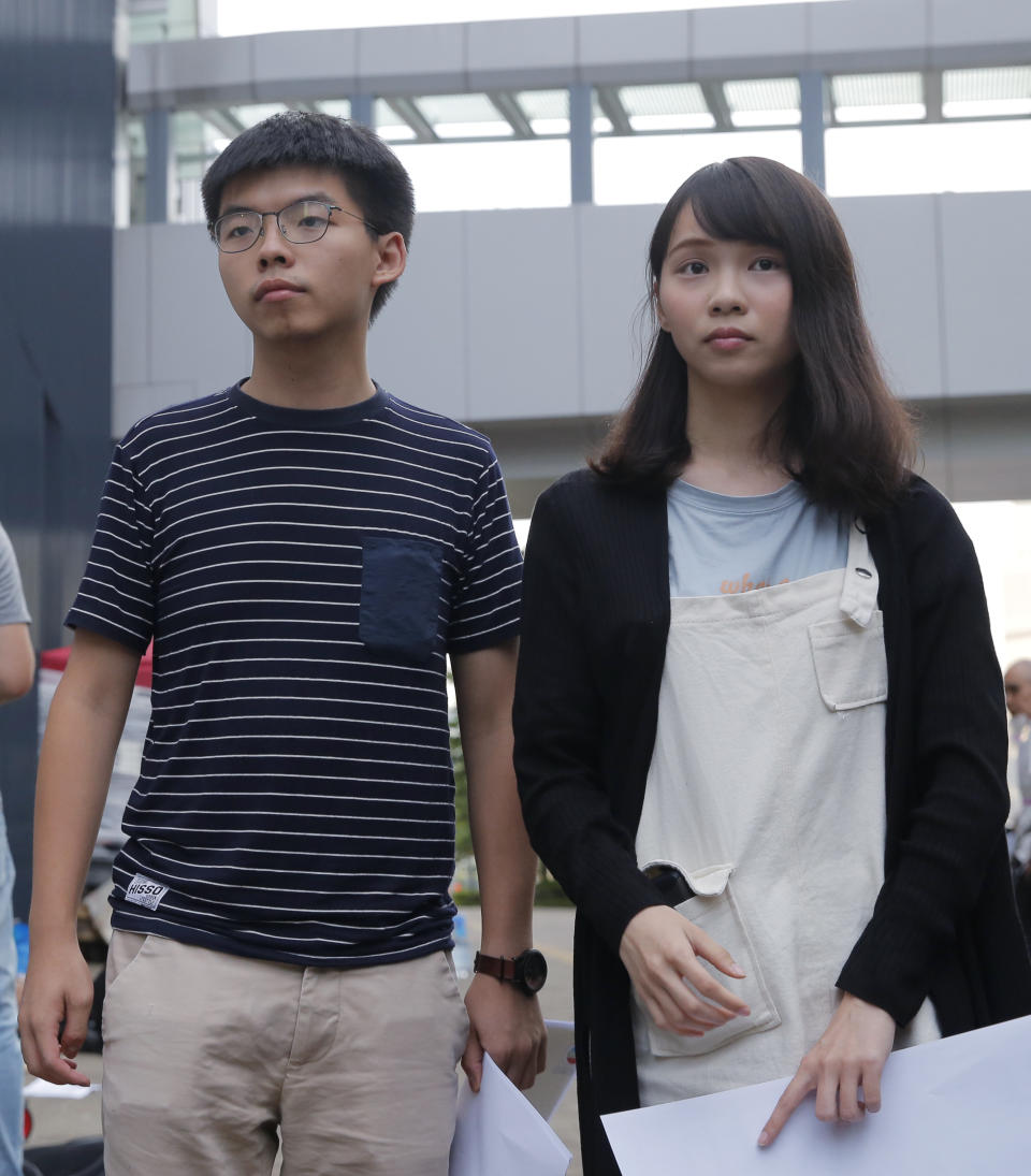 In this June 18, 2019, photo, pro-democracy activists Agnes Chow, right, and Joshua Wong meet media outside government office in Hong Kong. Demosisto, a pro-democracy group in Hong Kong posted on its social media accounts that well-known activist Joshua Wong had been pushed into a private car around 7:30 a.m. Friday, Aug. 30, 2019 and was taken to police headquarters. It later said another member, Agnes Chow, had been arrested as well. (AP Photo/Kin Cheung)