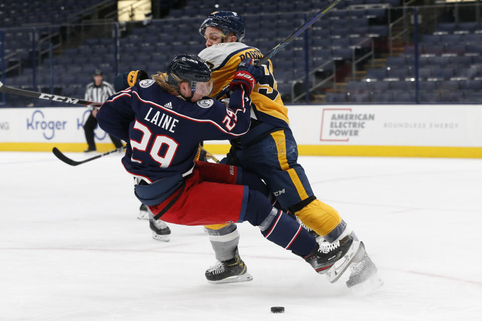 Nashville Predators' Mark Borowiecki, right, knocks Columbus Blue Jackets' Patrik Laine to the ice during the second period of an NHL hockey game Thursday, Feb. 18, 2021, in Columbus, Ohio. (AP Photo/Jay LaPrete)