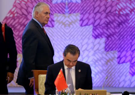 U.S. State Secretary Rex Tillerson, left, passes by the table of Chinese Foreign Minister Wang Yi at the start of the 7th East Asia Summit Foreign Ministers' Meeting and its dialogue partners as part of the 50th ASEAN Ministerial Meetings in Manila, Philippines August 7, 2017. REUTERS/Aaron Favila/Pool