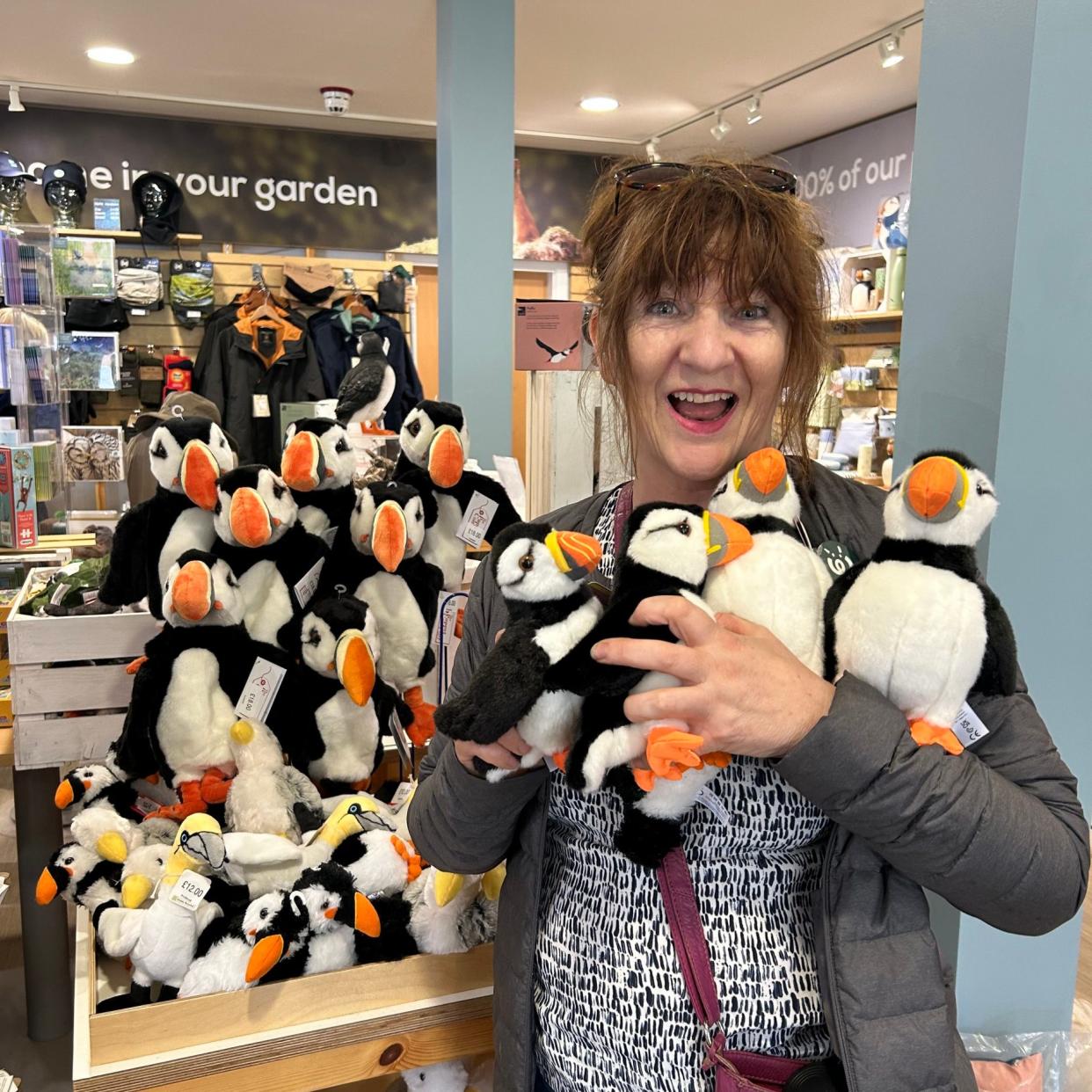 Judith Woods clutching toy puffins in the RSPB Bempton Cliffs gift shop