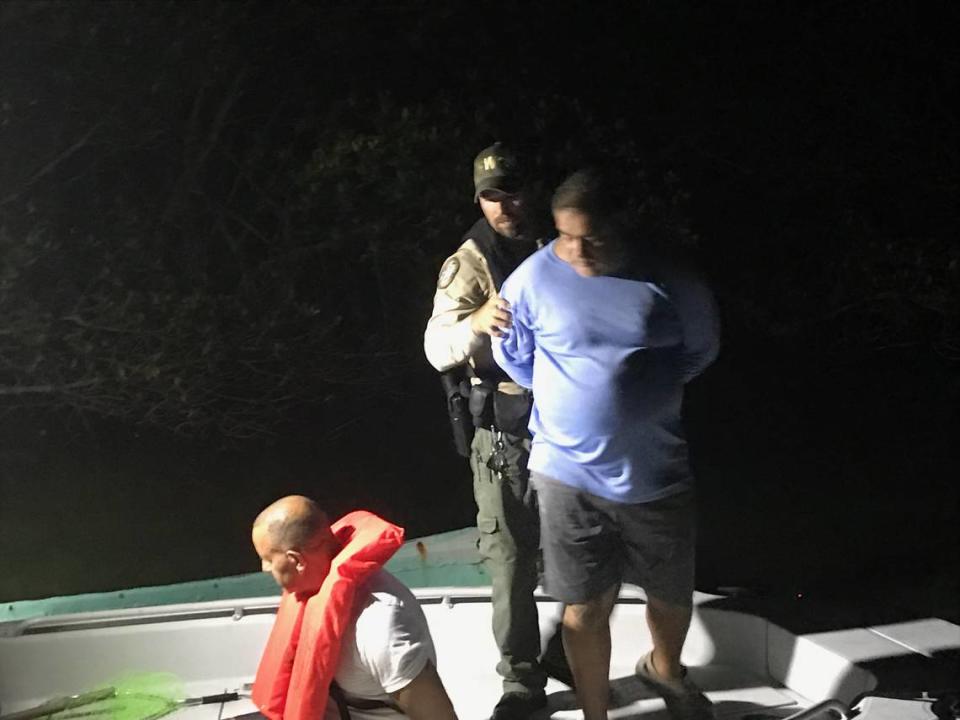 A Florida Fish and Wildlife Conservation Commission officer handcuffs a man after the officer and his colleagues said they found three men with more than 15 lobsters on Tuesday, July 24, 2018, an hour before the miniseason began on the sought-after crustaceans.