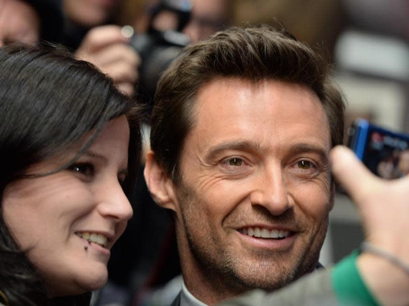 Ein Fan fotografiert sich und Schauspieler Hugh Jackman in Berlin vor der Premiere des Films «Prisoners». Foto: Sören Stache/