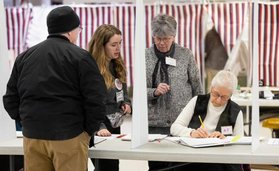 Kit DeVries, far-right, an election volunteer, helps a voter with their ballot as the New Hampshire Presidential primaries take place inside a polling site at Christ the King Parish Hall on Tuesday, Jan. 23, 2024, in Concord, New Hampshire.