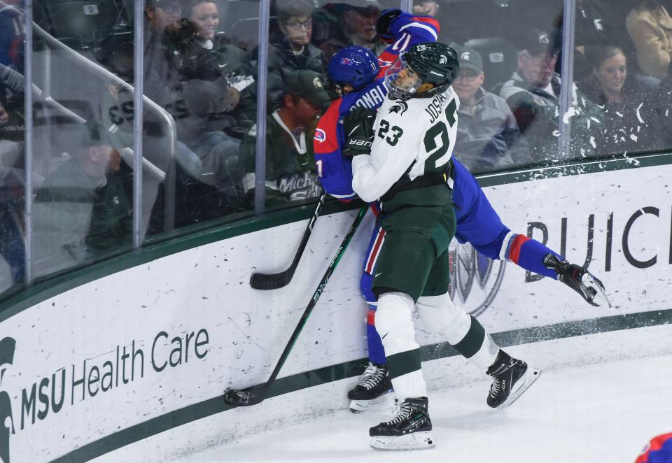 MSU's Jagger Joshua checks Edvard Nordlund of UMass-Lowell  Thursday, Oct. 13, 2022, at Munn Ice Arena in East Lansing.