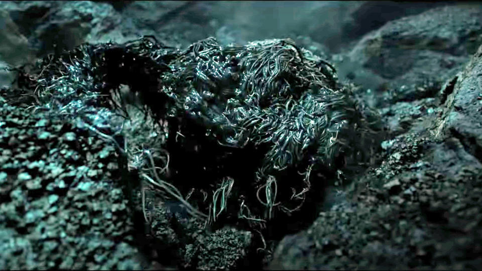 A smily monstrosity emerges from a rocky pit in The Rings of Power season 2