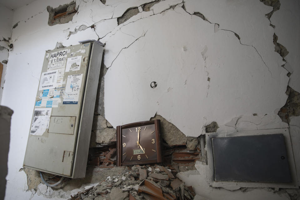 In this Thursday, Nov. 28, 2019 photo, a wall clock that was stoped working during the time of the deadly earthquake that struck in Albania early Tuesday, is seen inside a damaged building in the city of Durres.(AP Photo/Petros Giannakouris)