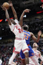 Chicago Bulls guard Javonte Green, left, competes for a rebound against New York Knicks center Mitchell Robinson during the first half of an NBA basketball game in Chicago, Tuesday, April 9, 2024. (AP Photo/Nam Y. Huh)