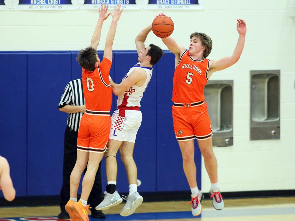 Heath's Ben Mason (5) and Preston DeVito stop Lakewood's Adam Crawford's drive to the basket on Friday.