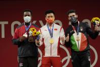 Gold medalist Lyu Xiaojun of China, center is flanked by silver medalist Zacarias Bonnat Michel of Dominican Republic, left, and bronze medalist Antonino Pizzolato of Italy, on the podium of the men's 81kg weightlifting event, at the 2020 Summer Olympics, Saturday, July 31, 2021, in Tokyo, Japan. (AP Photo/Luca Bruno)