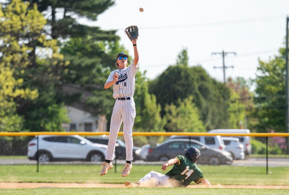 Conwell-Egan's Chase Forester (8) goes to catch the baseball as Lansdale Catholic's Brian Trailes (14) slides to second base during their Catholic League baseball game in Fairless Hills on Monday, April 29, 2024.