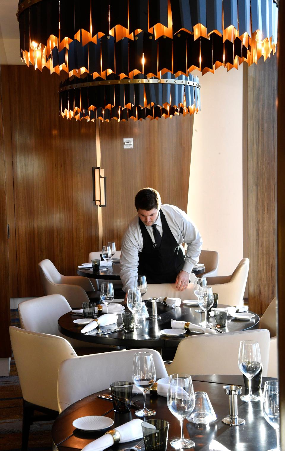 A waiter prepares for the night's guests inside Bourbon Steak on the 34th floor of the JW Marriott hotel.