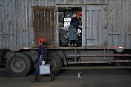 Workers downloading electronic waste about to be recycled are seen in a warehouse at the government-sponsored recycling park in the township of Guiyu, Guangdong Province, China January 12, 2018. REUTERS/Aly Song