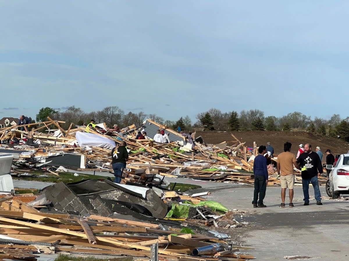 People dig through the rubble in Elkhorn following the tornado on Thursday 25 April 2024 (AP)